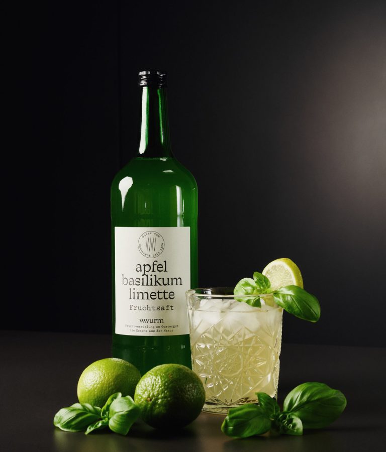 Apfel-Basilikum-Limettten-Saft in grüner Glasflasche